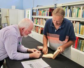 Ken Heffernan and Neil Gillespie examine rare books in the Gillespie Collection.