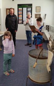Volunteer Marion Banyard assisting a family to find the treasure hunt curios.